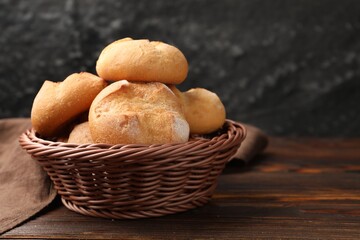 Fresh tasty buns on wooden table, closeup. Space for text