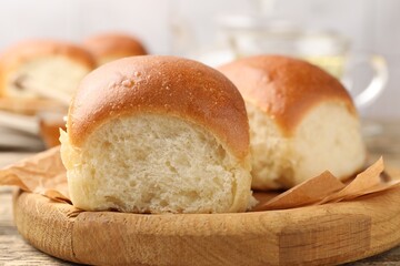 Fresh tasty buns on wooden table, closeup
