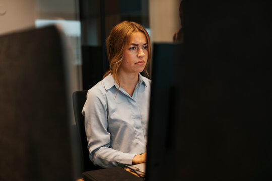 Worried businesswoman working on computer while sitting at desk in office