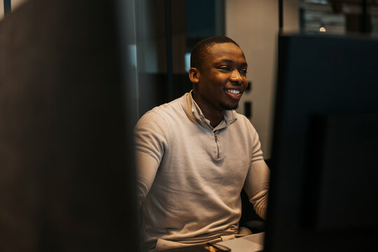 Smiling young businessman working late night at office