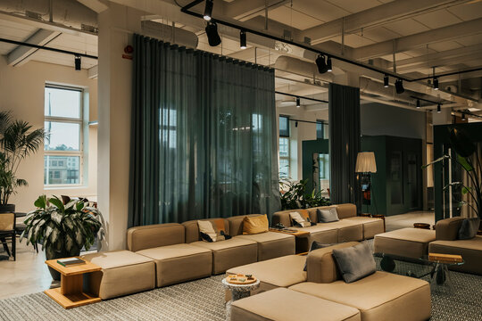Empty sofa and couches arranged in illuminated working space