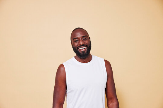 Portrait of happy bearded man standing against colored background