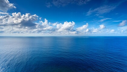 Obraz premium Cloudy Blue Sky Leaving For Horizon Above A Blue Surface Of The Sea