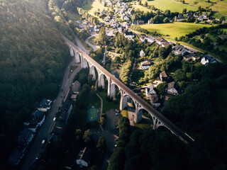 Obraz premium Breathtaking Drone View of a Railway Bridge from Directly Above, Symmetrical Infrastructure Crossing a Landscape in Natural Daylight