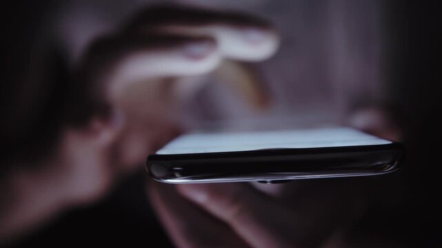 Evening News Check: Man Using Phone to Browse the Web Indoors