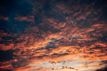 Fototapeta premium Intense Fiery Red Sunset Sky, Vibrant Crimson Afterglow Over a Dark Horizon in Natural Daylight