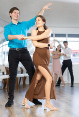 Obraz premium Young couples learning to dance latin american dances in a dance studio