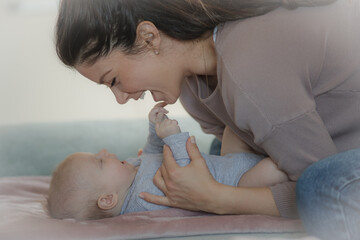 Baby girl lying on back and smiling at mom