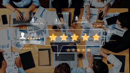 A top view of a diverse team engaged in discussions with laptops and documents, showcasing...