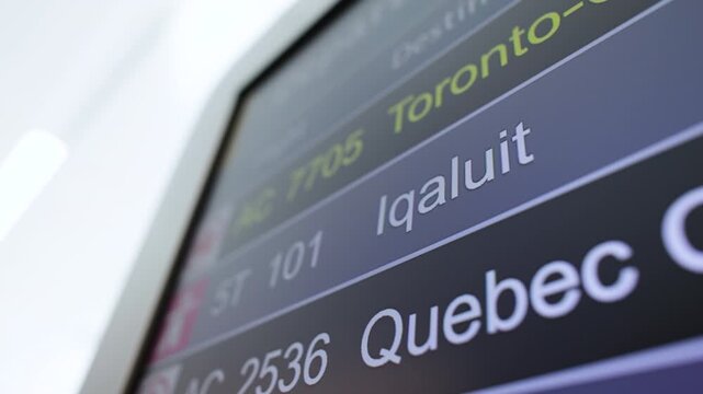 Iqaluit Canada Flight listing board at an airport showing delayed and cancelled flights in Canada