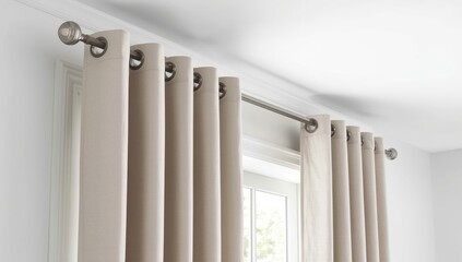 Contemporary grommet curtains drape from a stylish rod above in a well-lit room. The muted fabric enhances the simple design