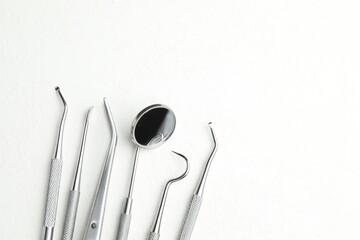 Many different dental tools on white table, flat lay. Space for text