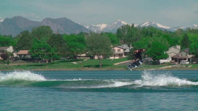 A slow-motion view of a person water skiing with a background of trees growing on a coast