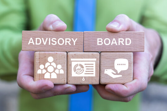 Concept of advisory board. Financial advisory services. Advisory committee. Change advisory board. Business person holding wooden blocks with icons sees the text ADVISORY BOARD.