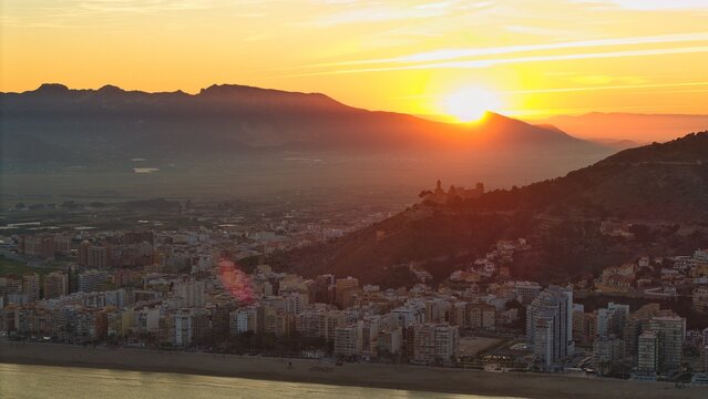 Sunset over Cullera castle and church on hilltop above Mediterranean coast &ndash; cinematic aerial view, Spain