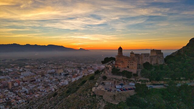 Sunset over Cullera castle and church on hilltop above Mediterranean coast &ndash; cinematic aerial view, Spain