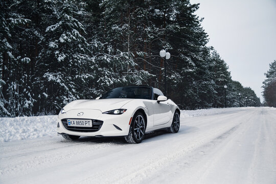 White roadster Mazda MX-5 Miata in the winter forest. Kyiv, Ukraine - February 2026.