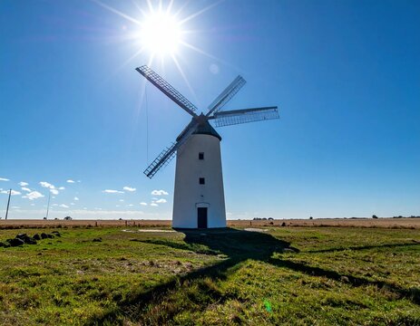 Historic Windmill Under Bright Sun in La Mancha Landscape.