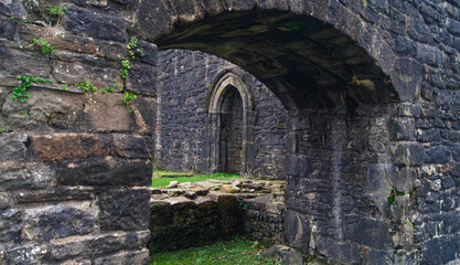Fototapeta premium Whalley Abbey ancient, old, ruins. Inside the ruins of the abbey, a stone archway leading to another room