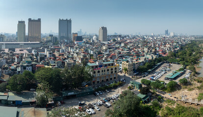 Obraz premium A panoramic view shows the urban landscape of Hanoi, Vietnam, with its dense housing, commercial buildings, and the Red River, showcasing the city's vibrant mix.