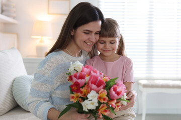 Happy Mother's Day. Mom and her daughter with bouquet of beautiful flowers at home