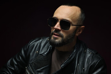 Obraz premium Fashion model. Handsome man in sunglasses on black background