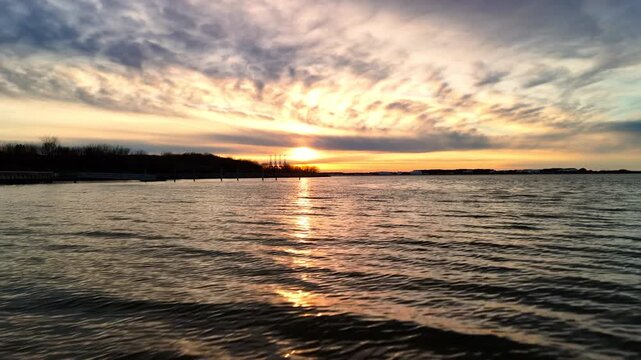 Dramatic sunset over the Elizabeth River industrial harbor and Norfolk Virginia skyline at golden hour