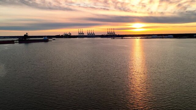 Dramatic sunset over the Elizabeth River industrial harbor and Norfolk Virginia skyline at golden hour