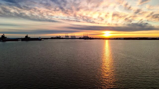 Dramatic sunset over the Elizabeth River industrial harbor and Norfolk Virginia skyline at golden hour