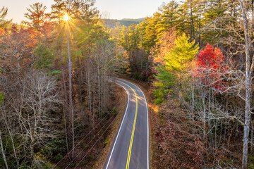 Road trip in fall season through Appalachian forest in Tennessee. Car driving on a winding road...
