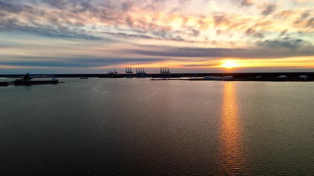Dramatic sunset over the Elizabeth River industrial harbor and Norfolk Virginia skyline at golden hour