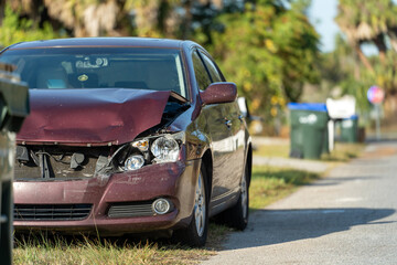 Vehicle damaged in traffic accident parked on street side in front of suburban houses. Insurance and transportation risk. © bilanol