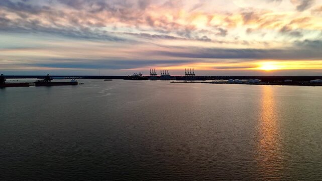 Dramatic sunset over the Elizabeth River industrial harbor and Norfolk Virginia skyline at golden hour