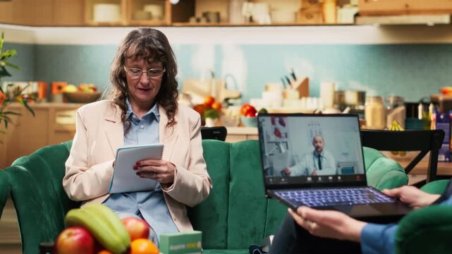 Woman pensioner writing advice and recommendations during video call with doctor, remote virtual consultation at home. Telemedicine and telehealth takes notes of medical guidance.