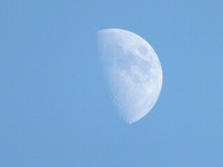 Half moon in soft blue daytime sky minimal background © RawProduct