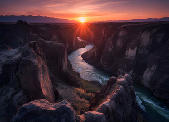 Sunset over a winding river in a deep rocky canyon