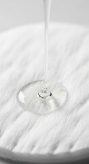 Liquid being poured onto a textured white surface creating ripples from a close-up viewpoint