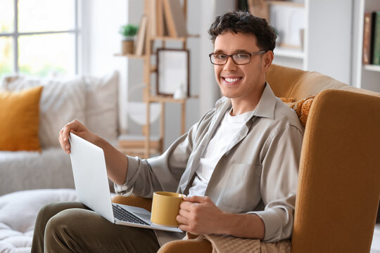 Male screenwriter with laptop and coffee writing script in office