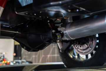 Close up of car driveshaft and rear axle underneath vehicle