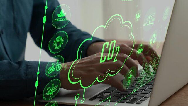 A person types on a laptop with vibrant green graphics representing sustainable energy concepts and CO2 reduction, highlighting the importance of environmental technology. Cipher