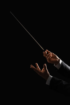 Male conductor's hands on black background