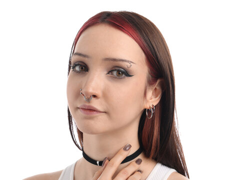 Portrait of beautiful young woman with different face piercings and choker on white background
