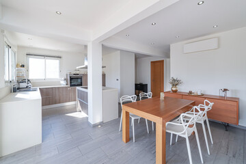 Modern open kitchen and dining area in bright apartment interior.