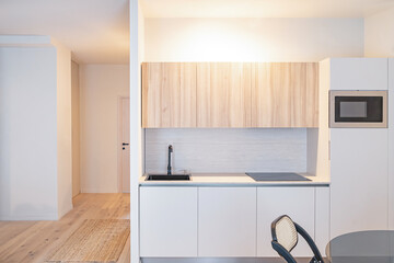 Minimalist modern kitchen in small apartment interior.