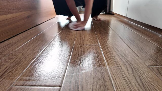 A housewife cleans a house or apartment. Mopping the floor with a damp cloth