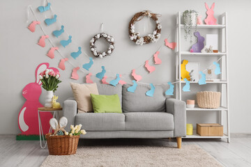 Interior of living room decorated for Easter with grey sofa, table and shelf unit