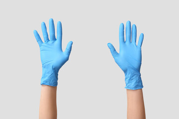 Obraz premium Female hands in medical gloves on grey background