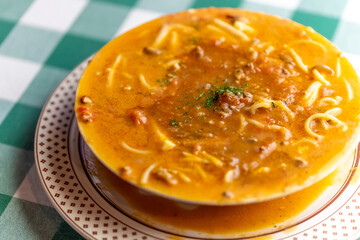 ひき肉の旨味が溶け出したソースにパスタを合わせた, ボロネーゼのスープパスタ。熱々のスープと麺が絡み合う様子や, 冬の温かメニュー, イタリアンレストランの新作を伝える販促・広告用素材に。 | a bolognese soup pasta with savory ground meat sauce and noodles in a warm broth.