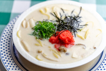 明太子、大葉、刻み海苔を添え、クリーミーな和風ホワイトソースにパスタを合わせた一皿。明太子のつぶつぶ感と薬味のアクセント、和洋折衷の優しい味わいを伝えるランチやディナーメニューの販促・広告用素材に。 | A Mentaiko (cod roe) and white sauce pasta topped with Shiso leaves and shredded Nori seaweed.