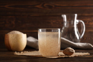 Glass of water with psyllium husk on wooden background © Pixel-Shot